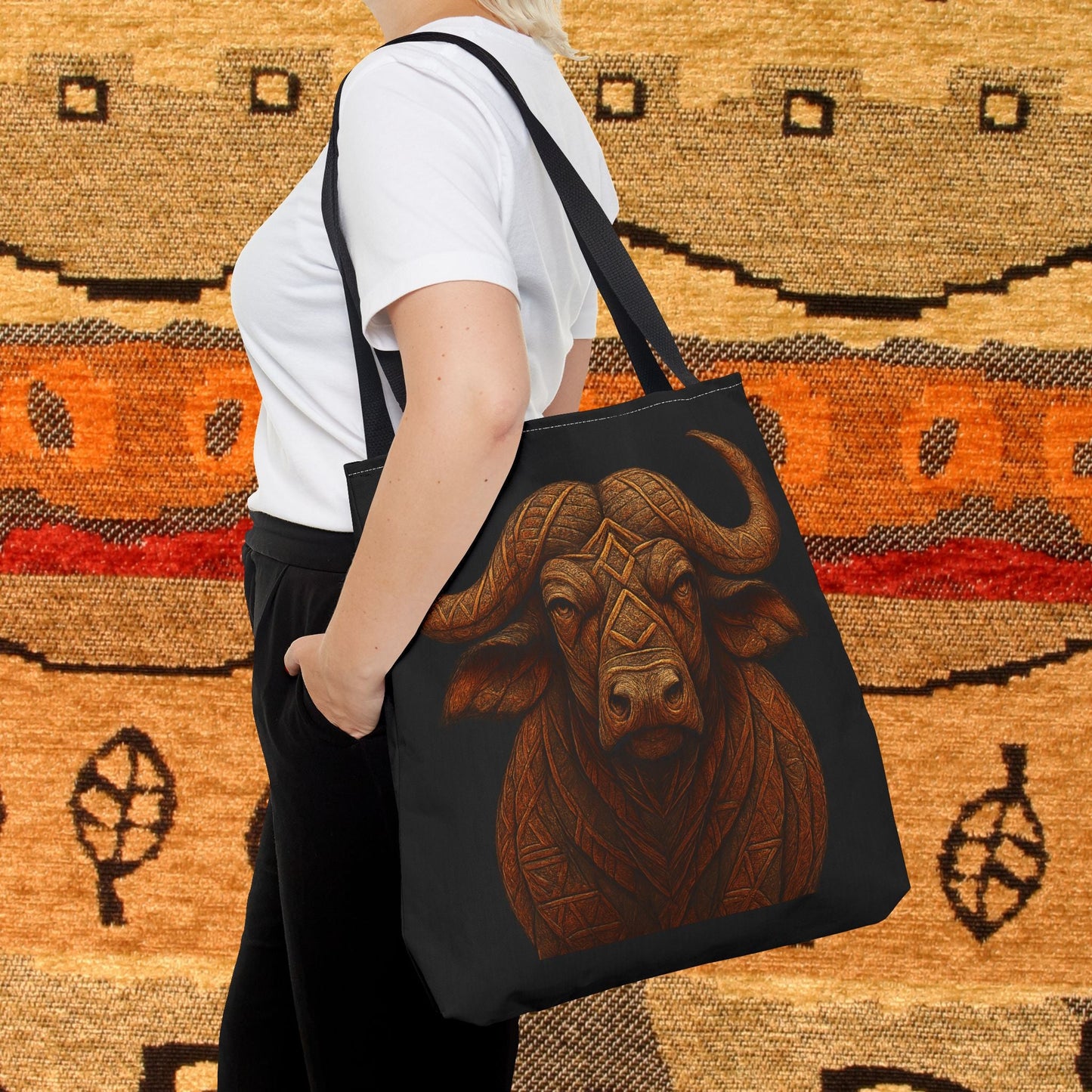 Mashafrica black tote bag with detailed brown carved buffalo artwork shown on shoulder against woven background