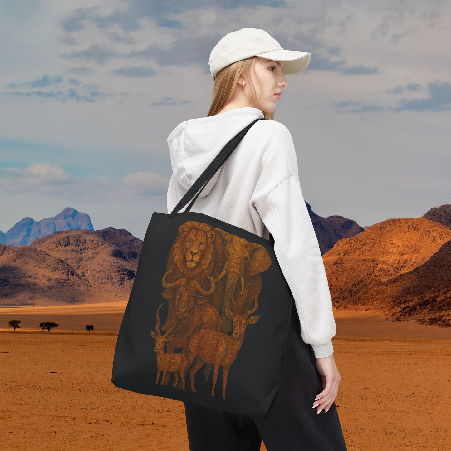Mashafrica tote bag black canvas with brown African wildlife print carried by woman in white hoodie and cap