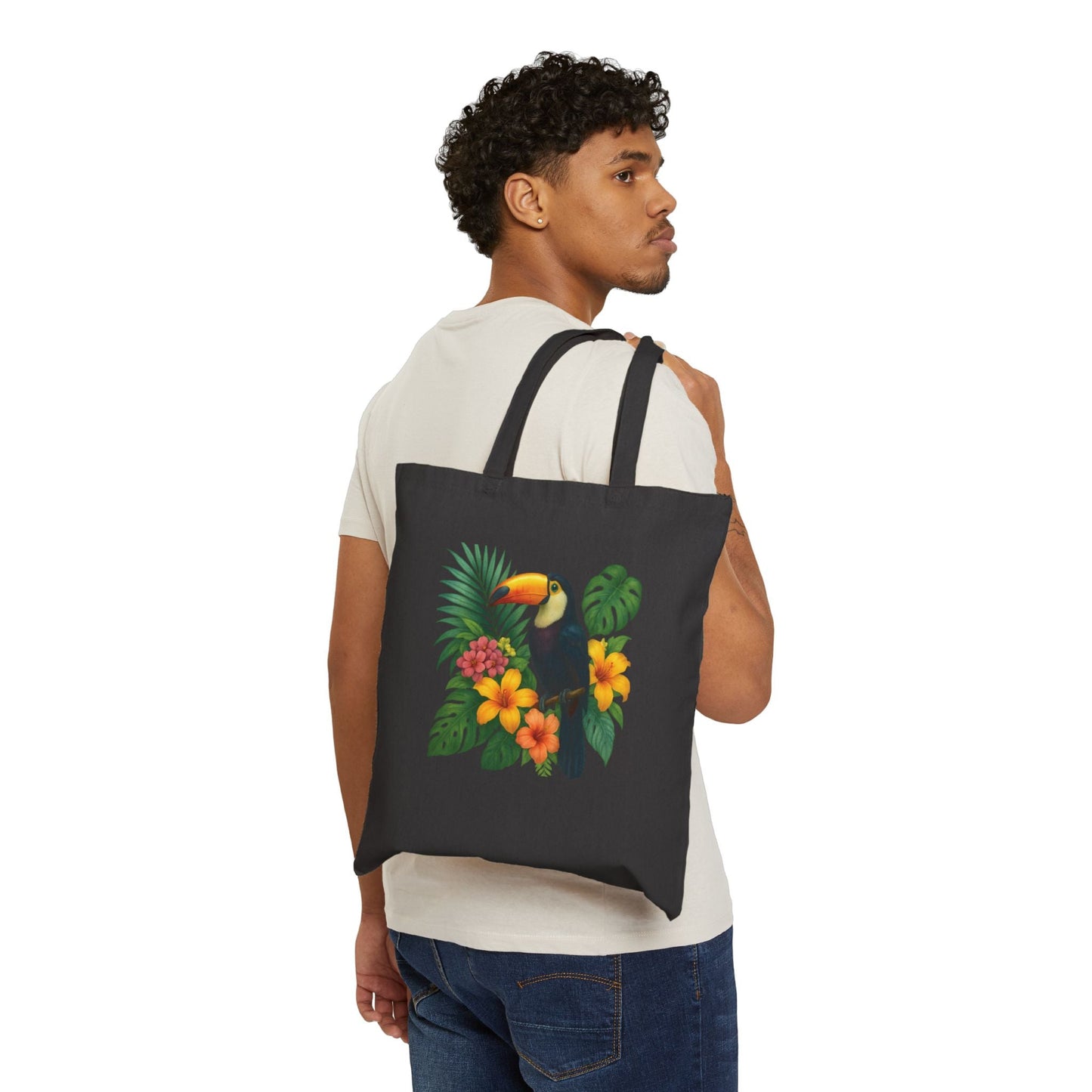 Mashafrica black tote bag with colorful toucan and tropical flower print carried over shoulder by model