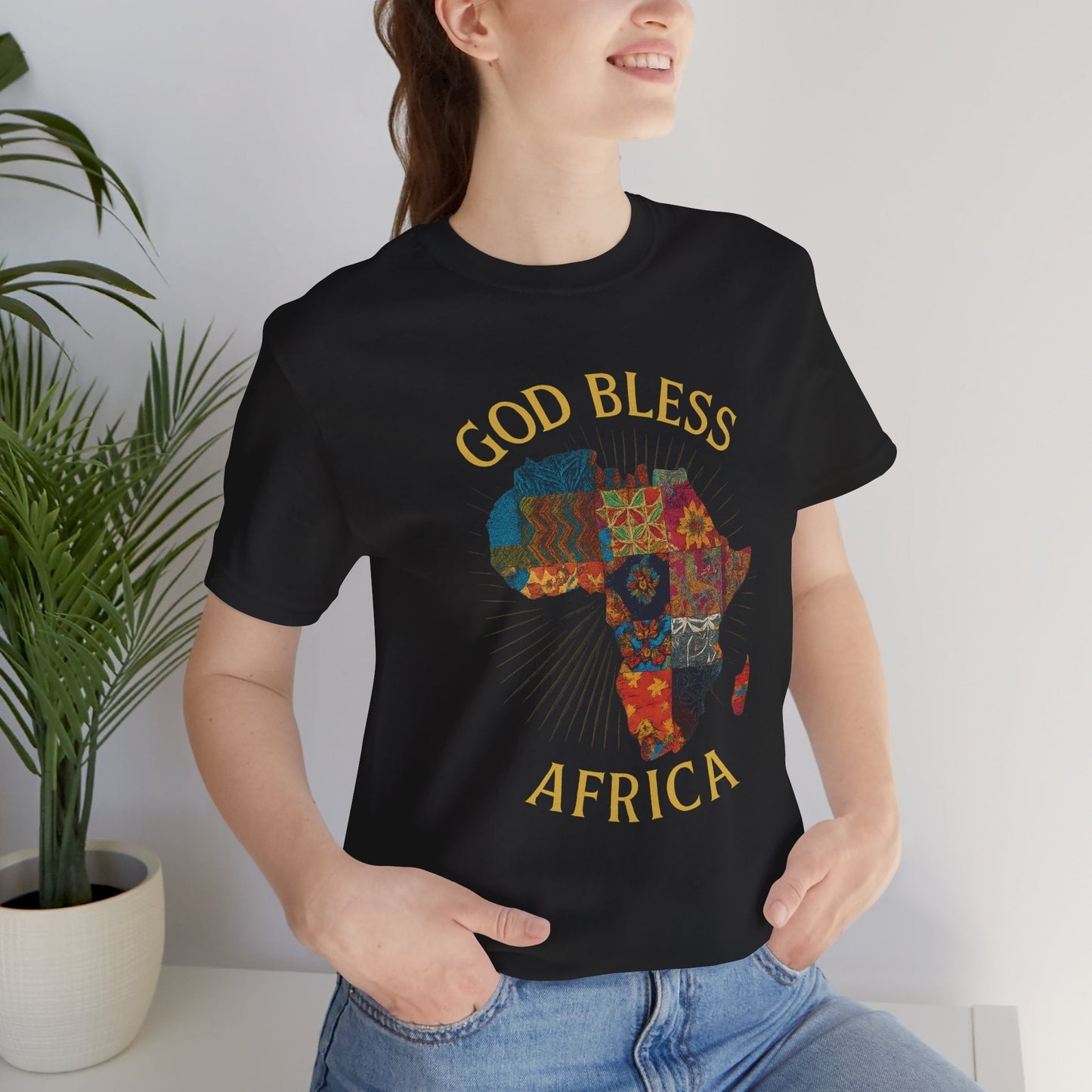 Mashafrica black T shirt with colorful patchwork map and GOD BLESS AFRICA print worn by smiling woman